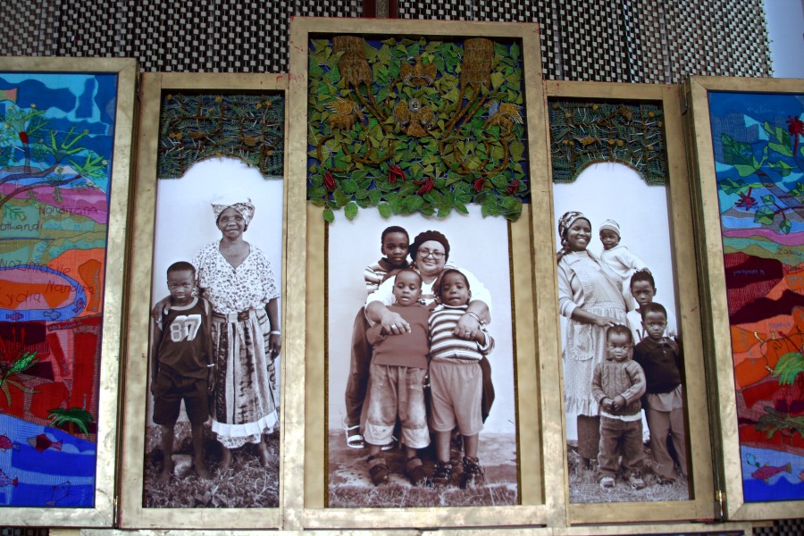 Life-size portraits of grandmothers and grandchildren beneath wire beadwork in the third layer