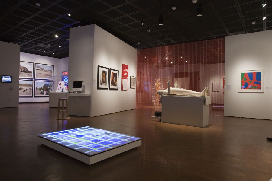 Installation view featuring sculpture, prints, photographic works, and a digital display