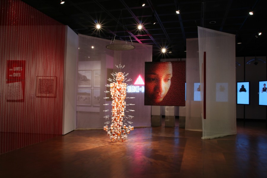 Wide gallery view featuring *Medicine Man* at center left, the UNAIDS cover image at center right, and additional works