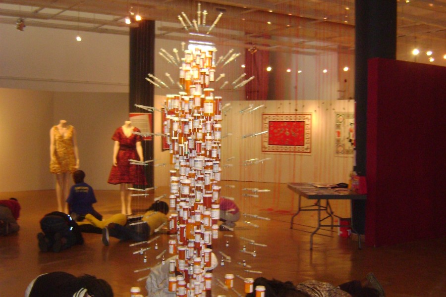 Visitors sitting and writing in front of Daniel Goldstein and John Kapellas’s *Medicine Man*