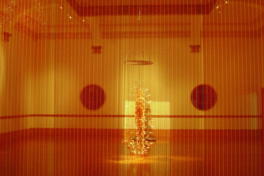 *Medicine Man* and the gallery seen through a red beaded curtain-like element