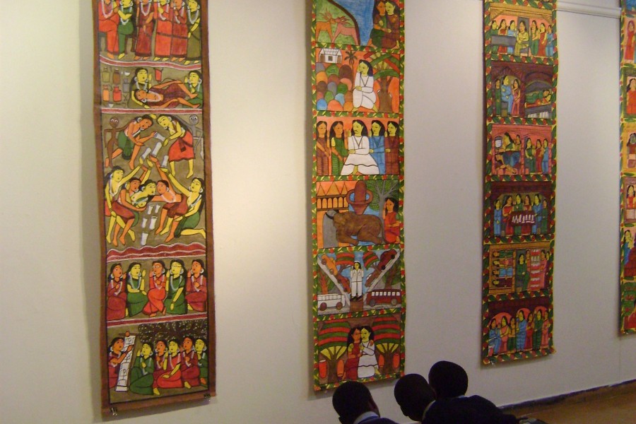 Visitors observing hanging illustrations in the gallery