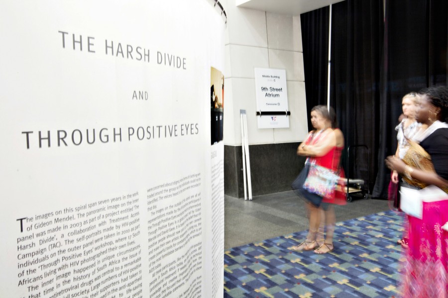 Visitors viewing Gideon Mendel’s *The Harsh Divide and Through Positive Eyes* spiral installation