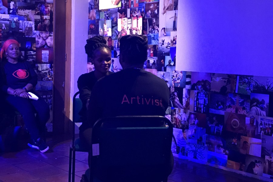 Two Through Positive Eyes artivists facing one another during live storytelling