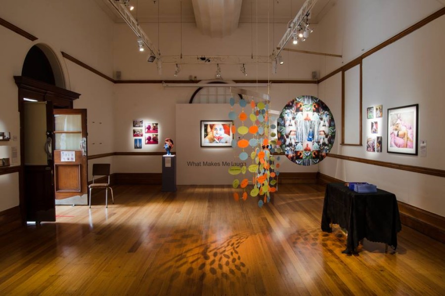 Multiple works by Through Positive Eyes artivists displayed in the gallery
