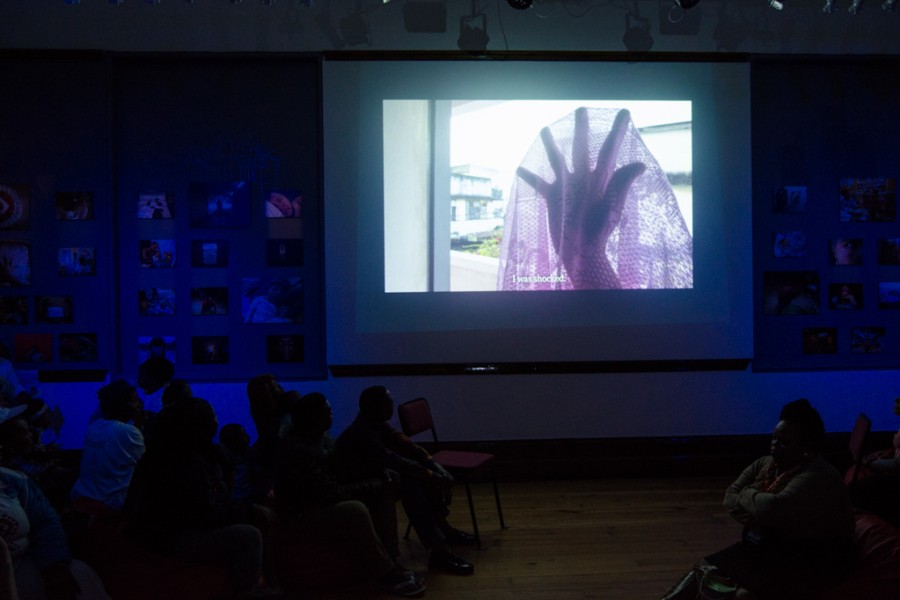 Visitors watching a short film before a storytelling performance in the Banishing Stigma Room
