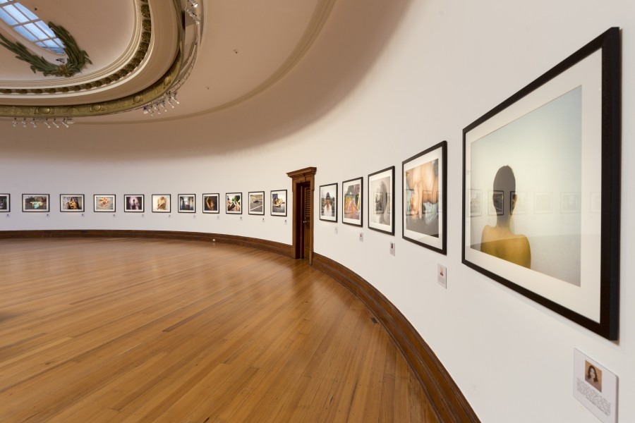 Row of framed photographs and story excerpts along the curved gallery wall