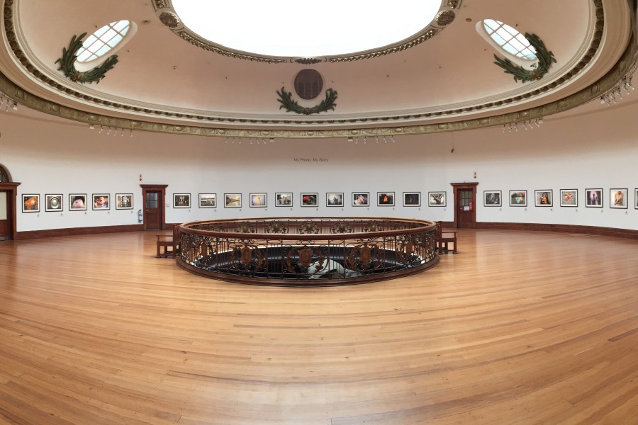 Panoramic gallery view of framed photographs and story excerpts in *My Photo. My Story.*