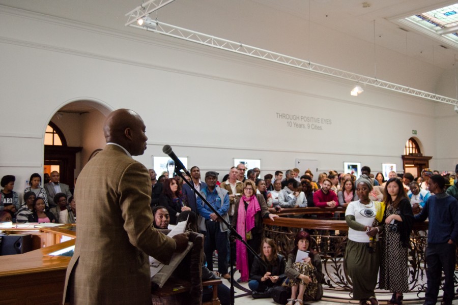 A person speaking to a crowd at the exhibition opening