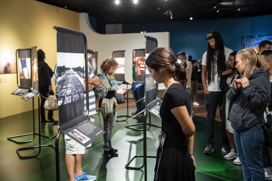 Visitors viewing artivist photographs, stories, and portraits by Gideon Mendel