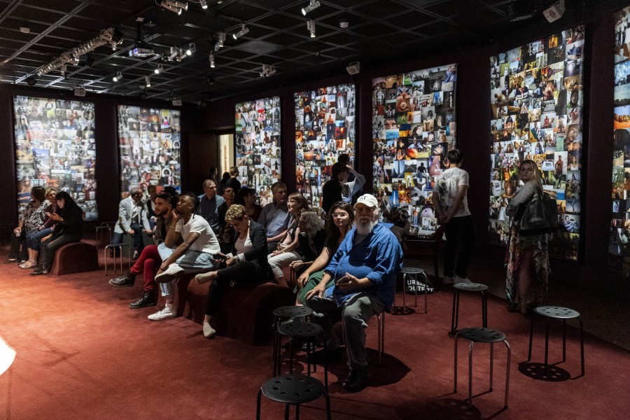 Audience seated in the Banishing Stigma Room with city photo-mosaic banners in the background