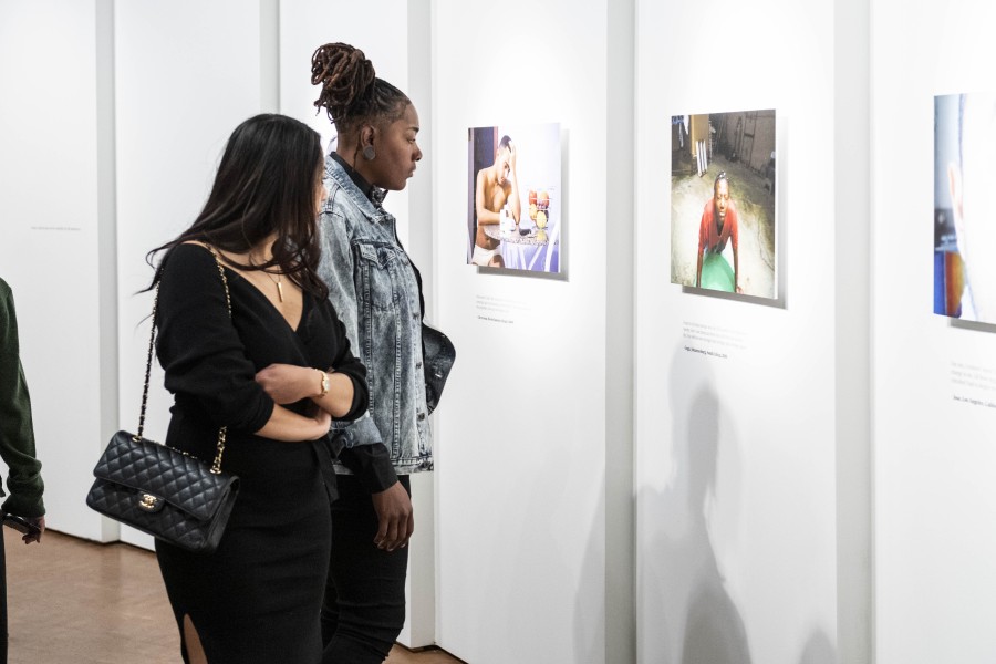 Visitors viewing photographs and stories by Through Positive Eyes artivists