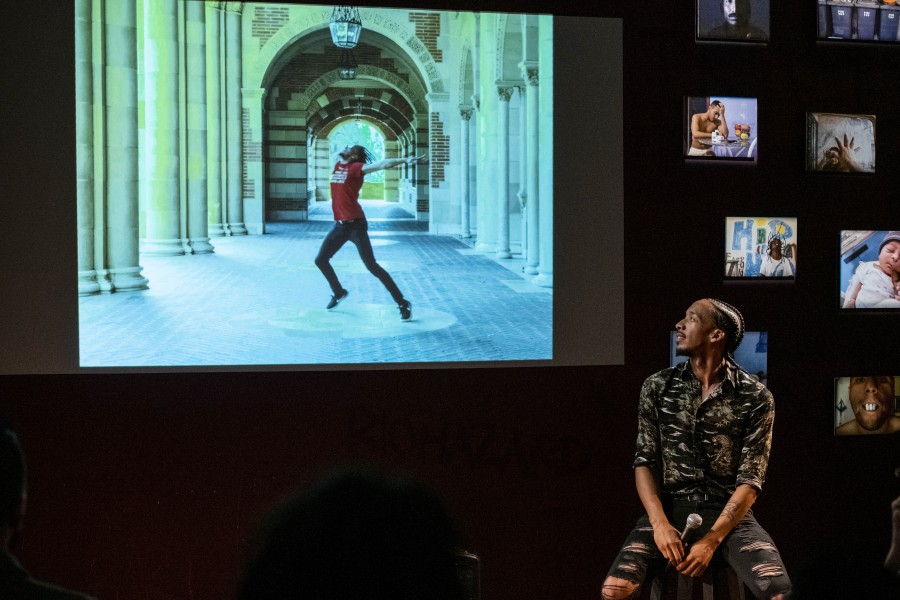Thomas storytelling before an audience with one of his photographs projected behind him