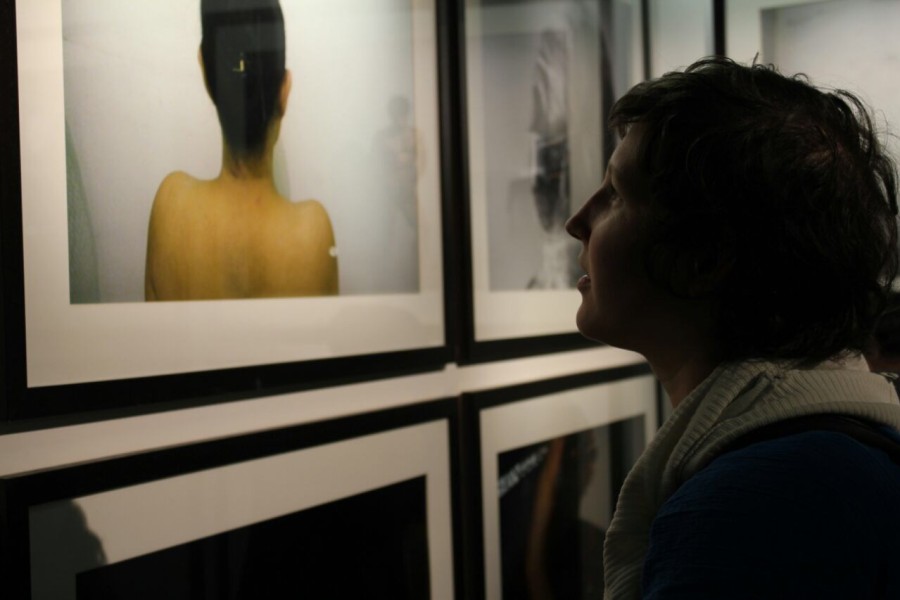 A visitor viewing a photograph by a Through Positive Eyes artivist