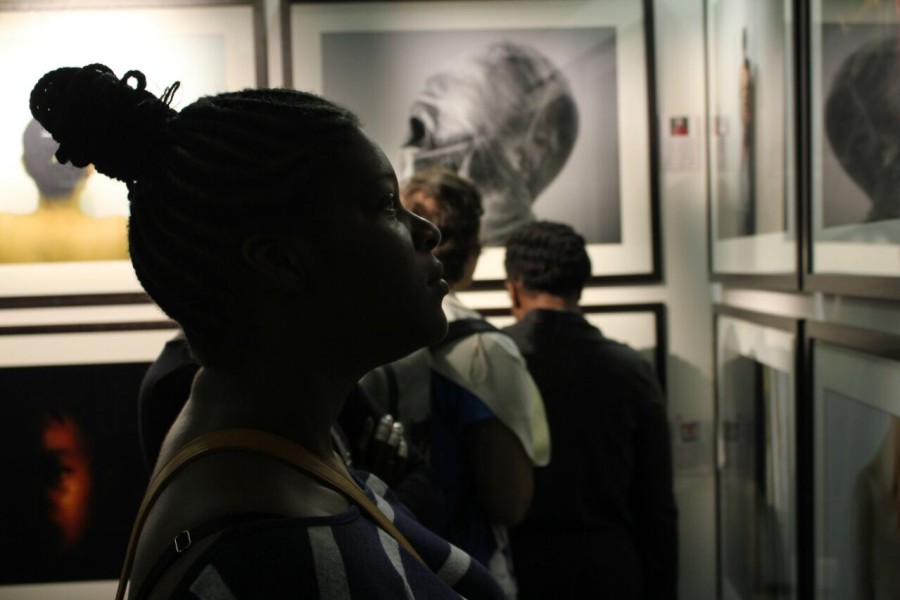 A visitor viewing a photograph by a Through Positive Eyes artivist