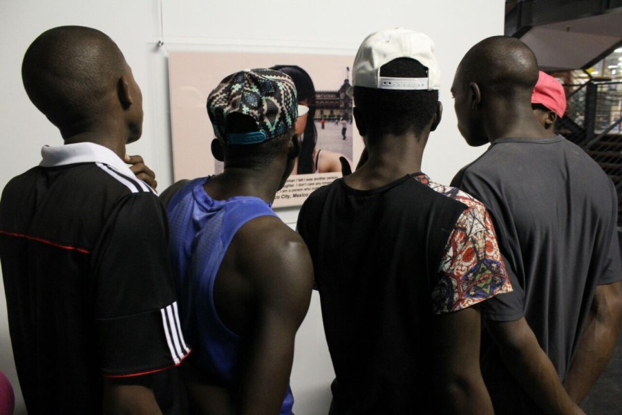 Visitors viewing a photograph by a Through Positive Eyes artivist
