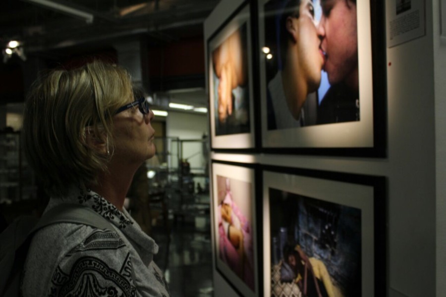 A visitor viewing a photograph by a Through Positive Eyes artivist