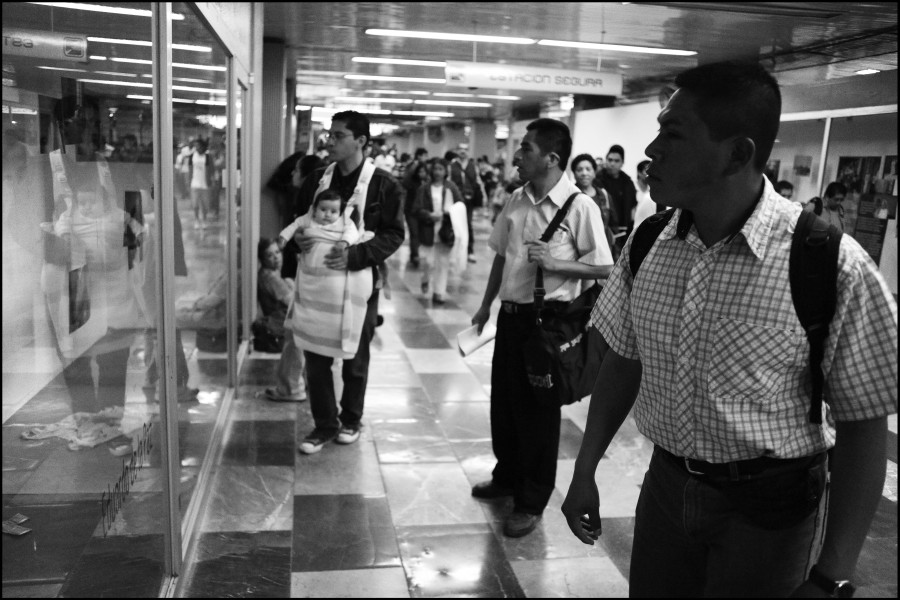 People passing by the exhibition while some stop to view photographs and stories