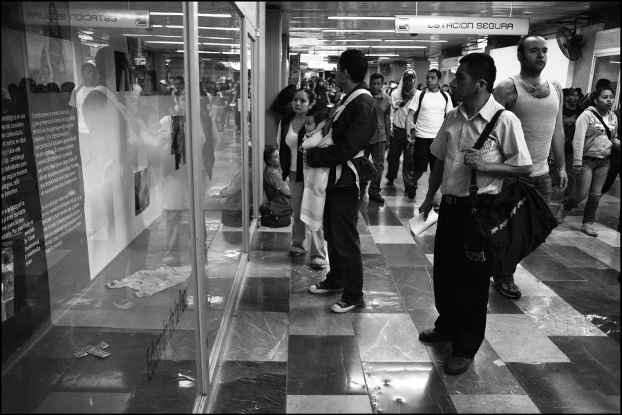 People passing by the exhibition while some stop to view photographs and stories