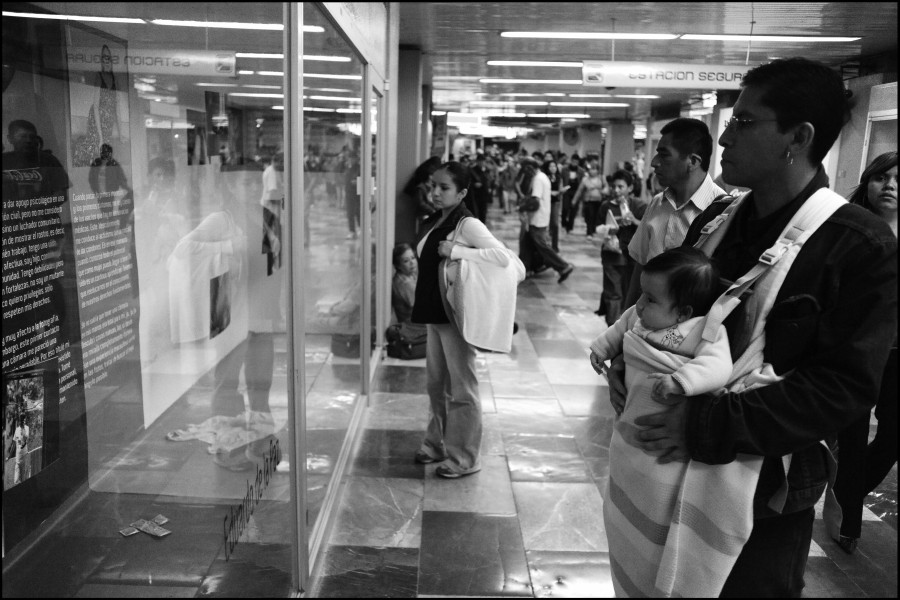 People passing by the exhibition while some stop to view photographs and stories