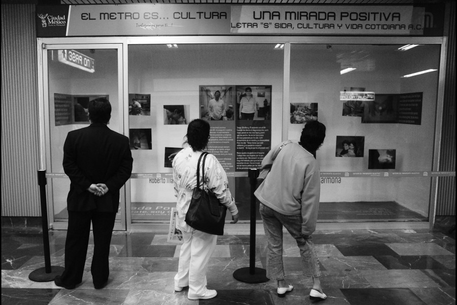People stopping to view photographs and stories by Through Positive Eyes artivists